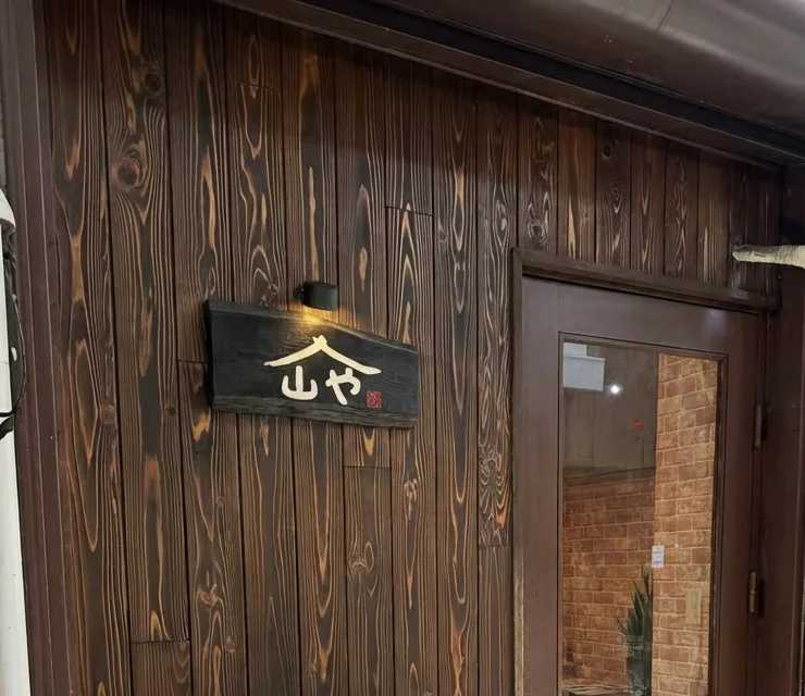 喫茶 山や の店先。黒い板壁に木の看板